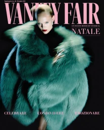 Model wearing a voluminous green faux fur coat and dark turtleneck against a black background for Vanity Fair Italia.