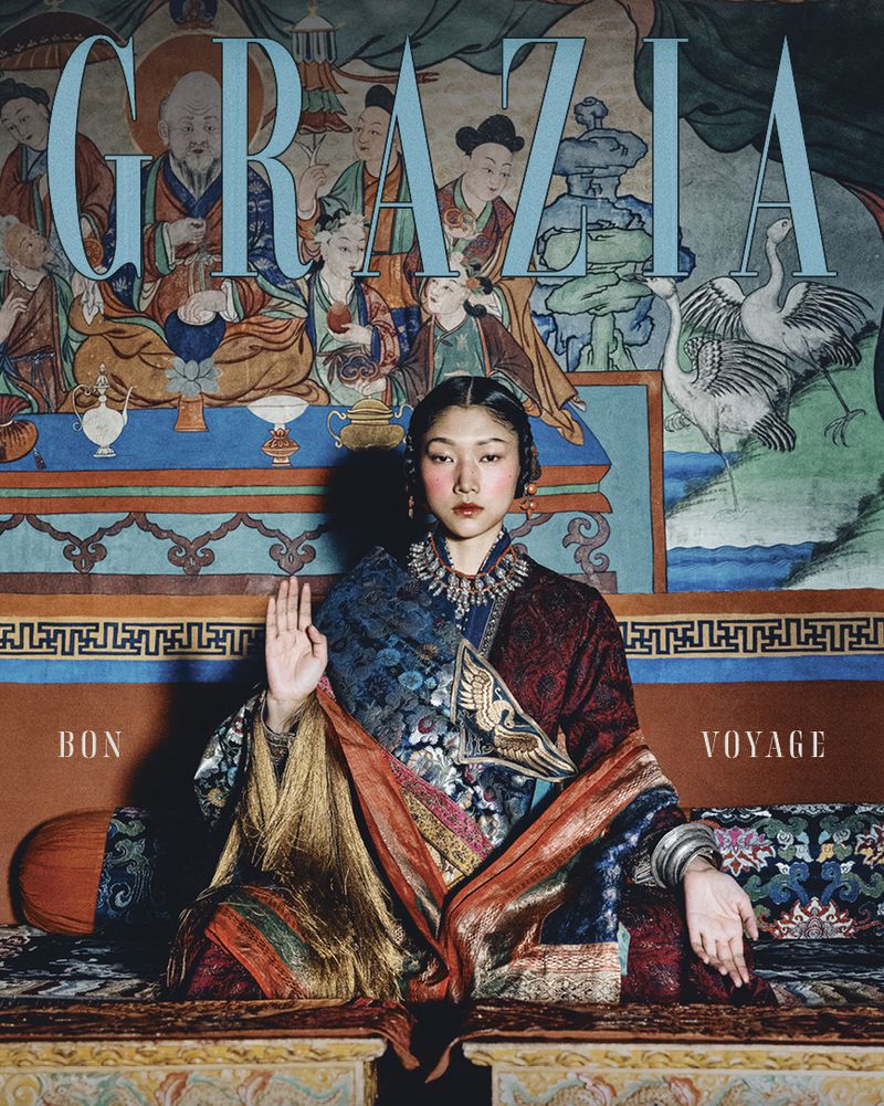 Fashion editorial shot of a young Asian woman in traditional attire against a painted backdrop, featured on the cover of Grazia magazine.
