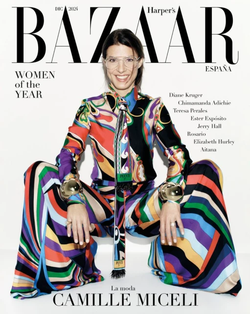 Camille Miceli cover of Harper's Bazaar España. Woman in colorful patterned outfit, large gold bracelets, glasses, seated pose on white.
