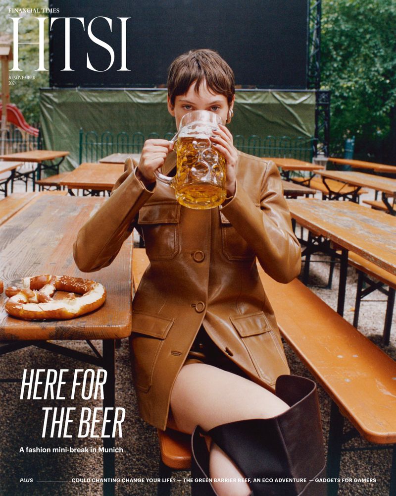 Magazine cover of woman drinking beer in Munich beer garden, wearing a brown jacket, with pretzel and Financial Times masthead.