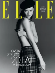 Model Kasia Struss wearing a black beret and plaid skirt against a neutral grey studio background for Elle Poland.