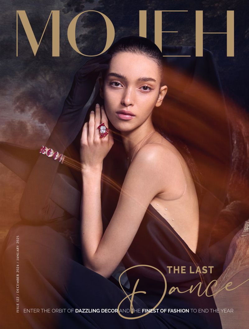 Magazine cover featuring a young woman with jewelry. She poses in front of an abstract, blurred background with gold-lettered text and editorial content.