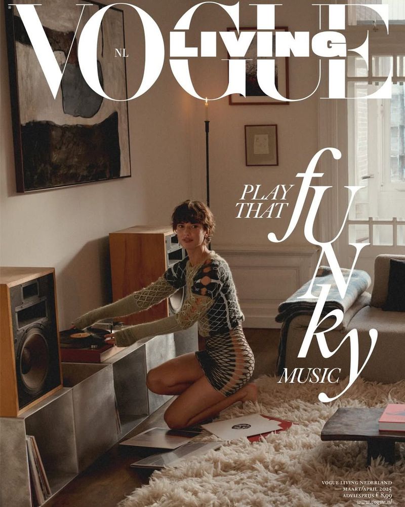 Vogue Living cover featuring a woman kneeling by record players, with vintage audio equipment and a modern interior setting, shot in warm light.