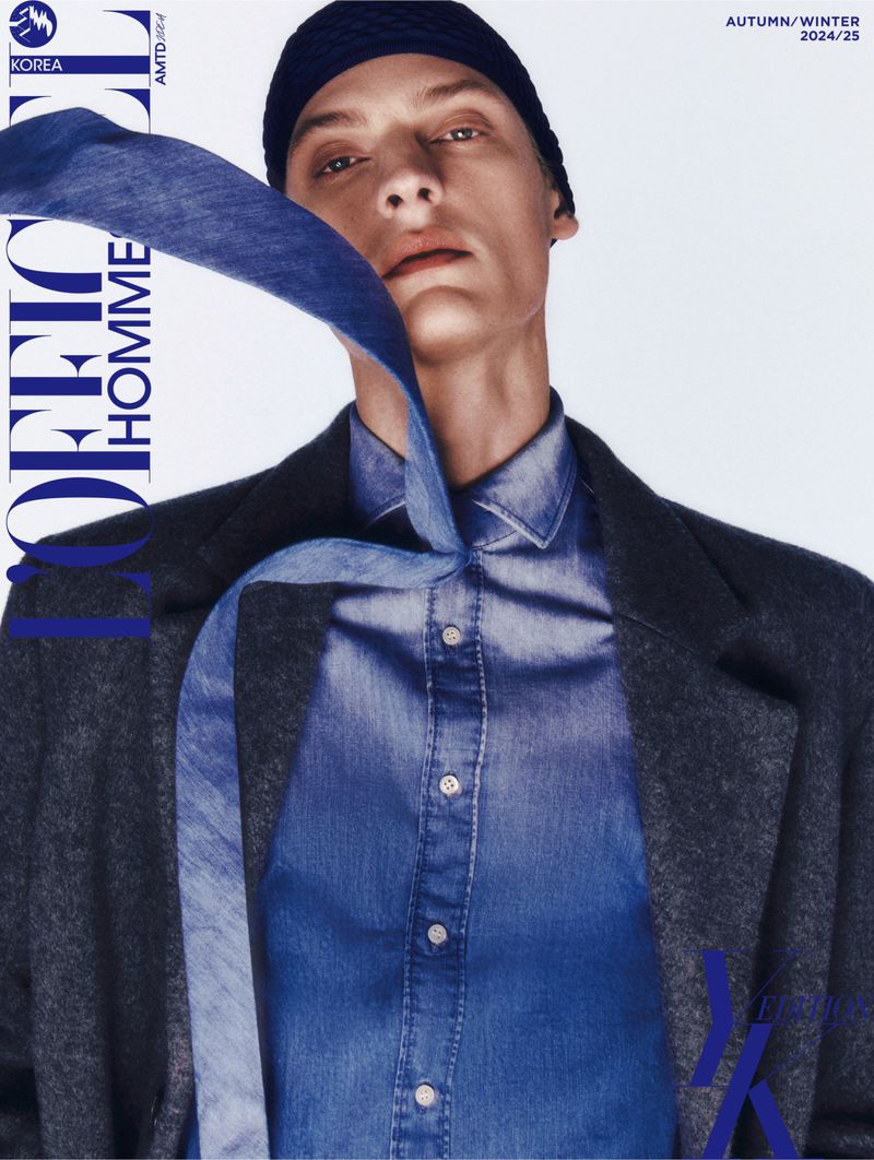 Fashion editorial magazine cover featuring a male model with a blue denim shirt, dark coat, and knit hat, promoting autumn/winter 2024/25.