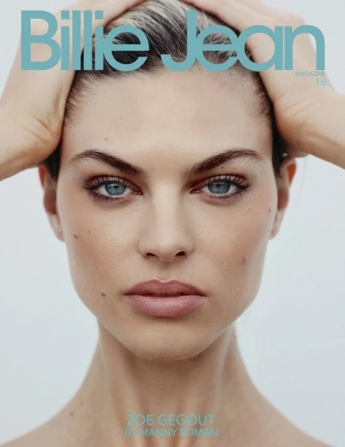 Close-up portrait of woman with blue eyes holding her hands up with 'Billie Jean Magazine 16' text on a light background.