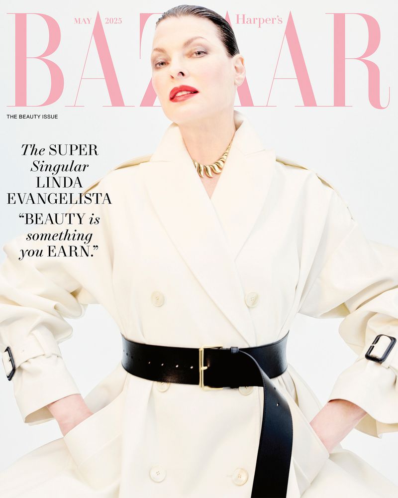 Linda Evangelista graces Harper's Bazaar May 2025 cover, wearing a trench coat cinched with a wide black belt, offering a direct gaze.