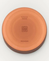 Terracotta ceramic base with embossed Loewe logo and Thyme typography centered against a clean white background.