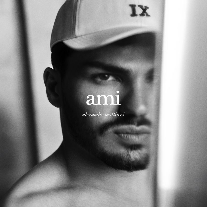 Black and white portrait of an adult male wearing a baseball cap, with the text 'ami alexandre mattiussi' superimposed.