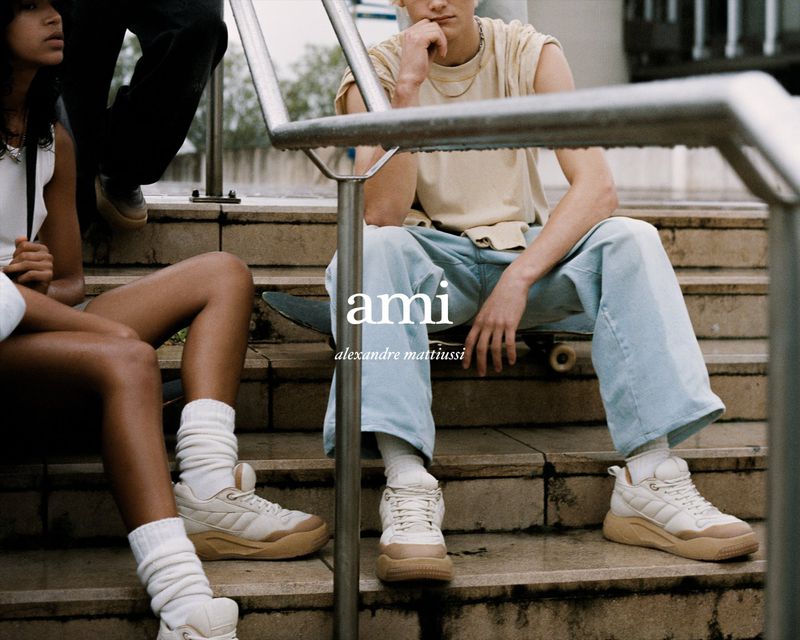 Skate style fashion campaign image featuring models sitting on outdoor concrete steps wearing sneakers and socks