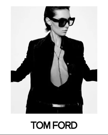 A woman poses in black attire and sunglasses against a white background for a Tom Ford advertisement, capturing high fashion.