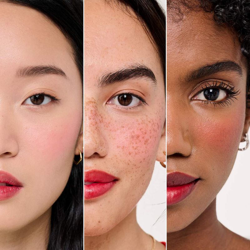 Close-up of three diverse women showcasing makeup; each has distinct skin tone and blush, highlighting beauty and cosmetic diversity.