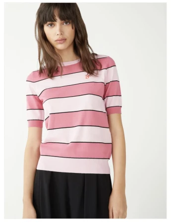 Model Rosa Kirakosyan wearing a pink striped short-sleeve knit top and black pleated bottoms against a white studio background.