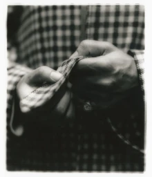 Close-up of hands touching patterned fabric in a black and white portrait for Present Space photographed by Javier Castan.