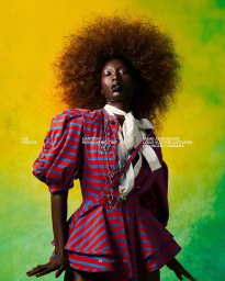 Model with voluminous afro hair wearing a red and blue striped top against a textured yellow and green background.