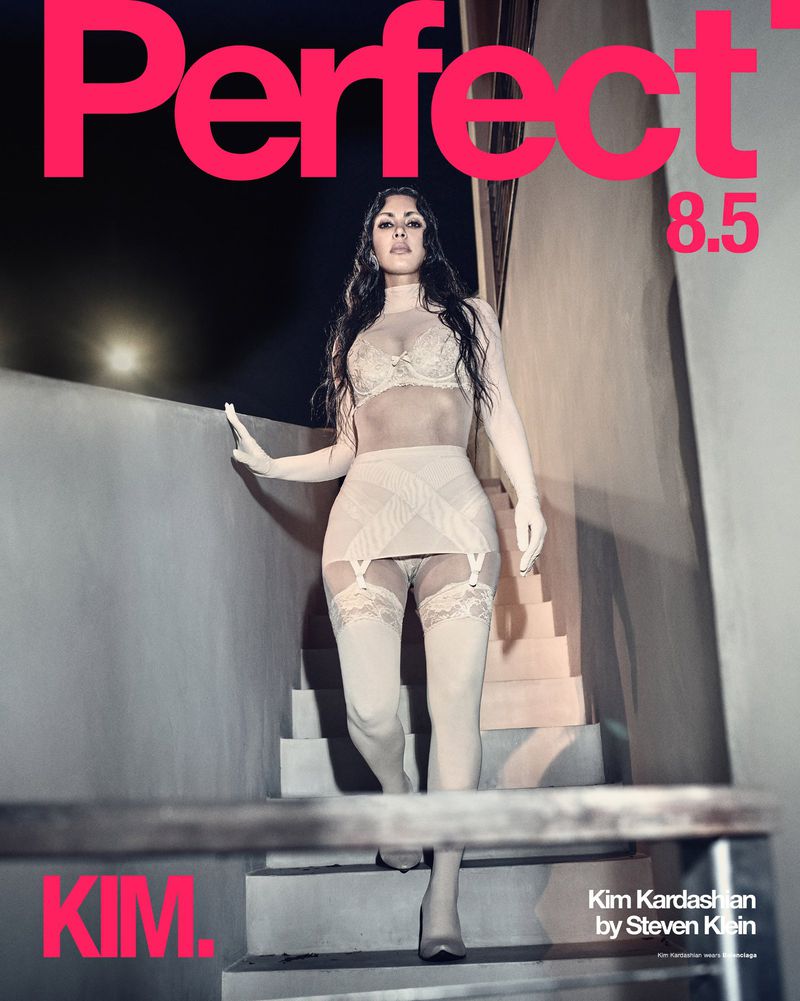 Kim Kardashian poses in lingerie on stairs for Perfect Magazine cover, shot by Steven Klein. Pink masthead and text on dark background.
