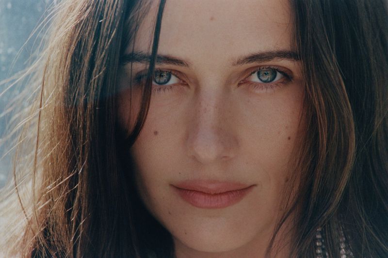 Close-up beauty portrait of Devon Lee Carlson looking directly at the camera with brown hair and blue-grey eyes for Russh magazine.
