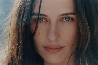 Close-up beauty portrait of Devon Lee Carlson looking directly at the camera with brown hair and blue-grey eyes for Russh magazine.