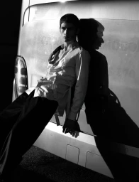 Monochrome fashion portrait of model Luka Tesic leaning against a vehicle for ModMod Magazine, photographed by Vincent van den Dries.