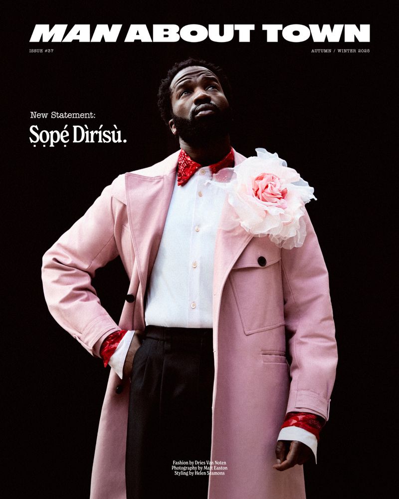 Magazine cover featuring a bearded Black male in a pink trench coat looking up against a dark background, promoting 'Man About Town'.