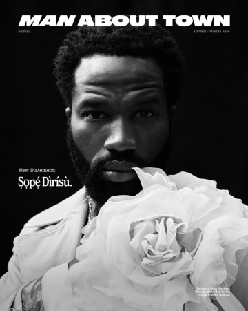 Portrait of actor Sope Dirisu holding a large white fabric flower for Man About Town magazine, photographed by Matt Easton in monochrome.
