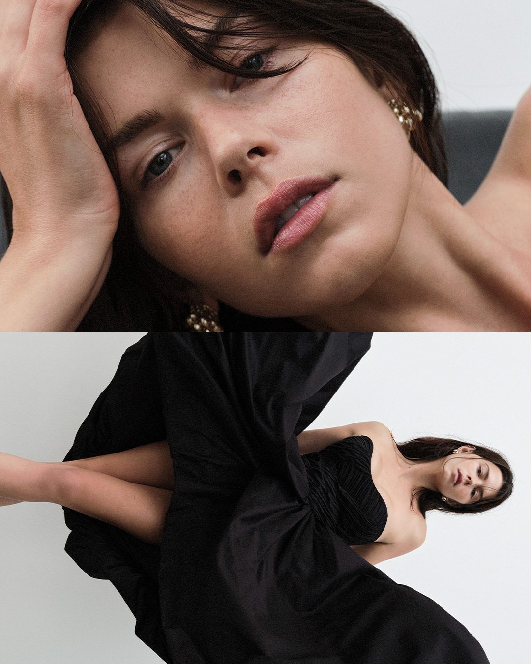A young woman lies against a grey surface in a strapless black dress with gold earrings in a beauty, fashion, and skincare portrait.