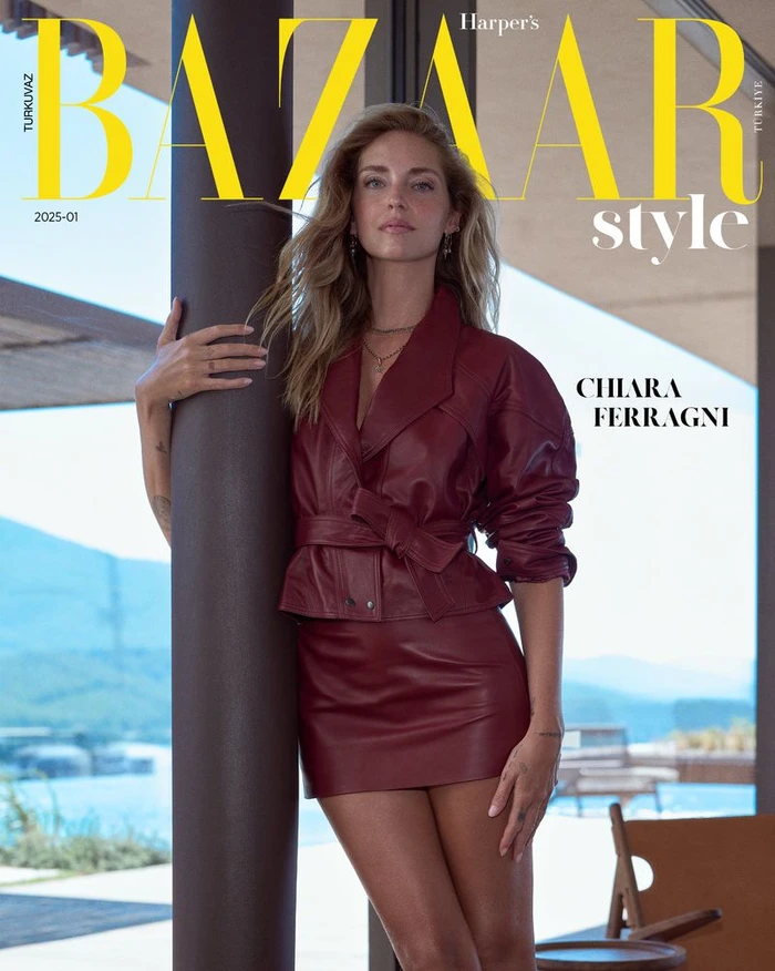 Chiara Ferragni wearing a burgundy leather jacket and matching skirt leaning against a dark pillar for a Harper's Bazaar Turkey cover.