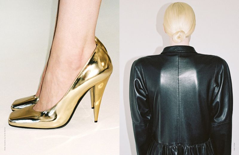 Rear view of a woman in a black leather dress next to a pair of feet wearing shiny gold high heel shoes on a white background.