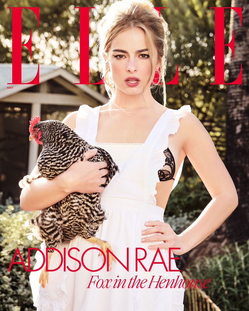 Elle magazine cover featuring Addison Rae holding a striped chicken. She wears a white dress, and the background shows a house and greenery.