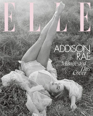 Monochrome magazine cover featuring Addison Rae lying on grassy field with legs raised up wearing sheer white lingerie