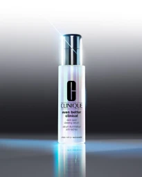 Clinique Even Better Clinical dark spot clearing serum bottle standing upright on a reflective surface with a bright blue light flare