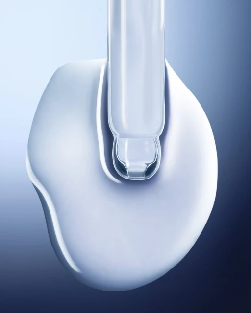 Close-up of a clear serum droplet with a glass dropper against a soft blue gradient background in a beauty or cosmetic product shot.