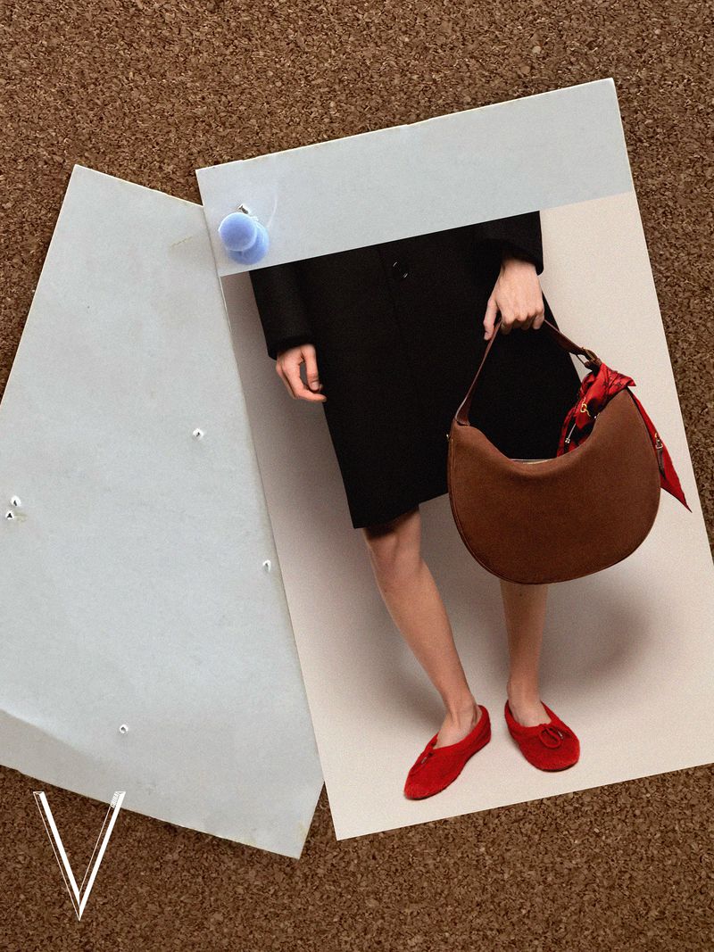 Fashion editorial image features an adult female holding a brown handbag with a scarf, a black dress, and red shoes on a neutral surface.