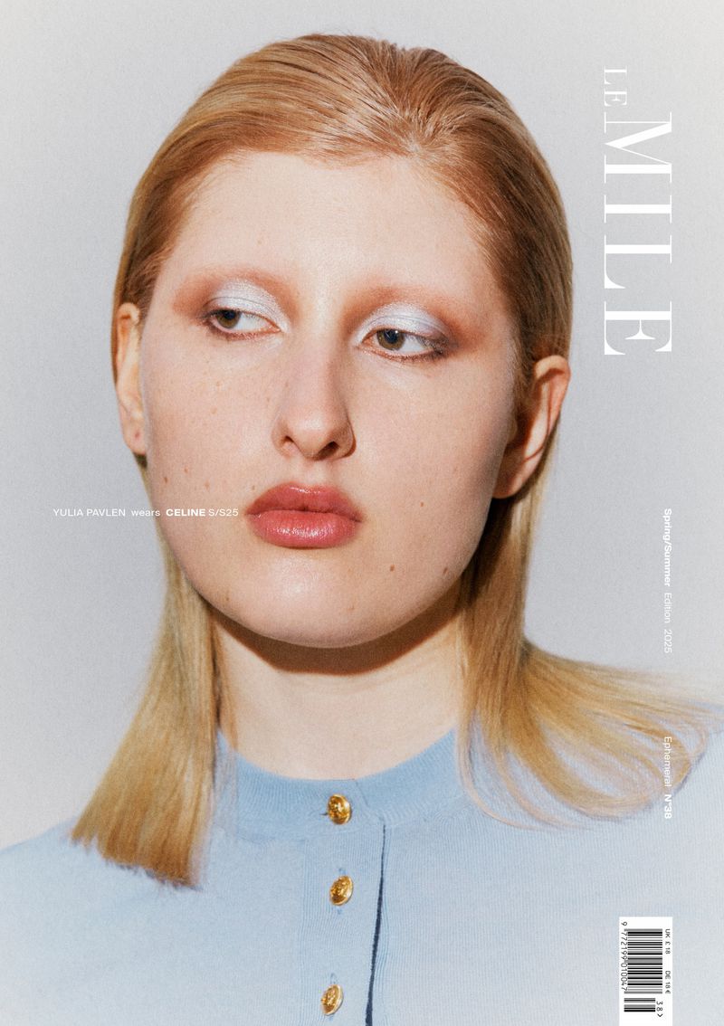 Magazine cover featuring a model with blonde hair and light blue shirt looking off-camera in a brightly lit studio setting.