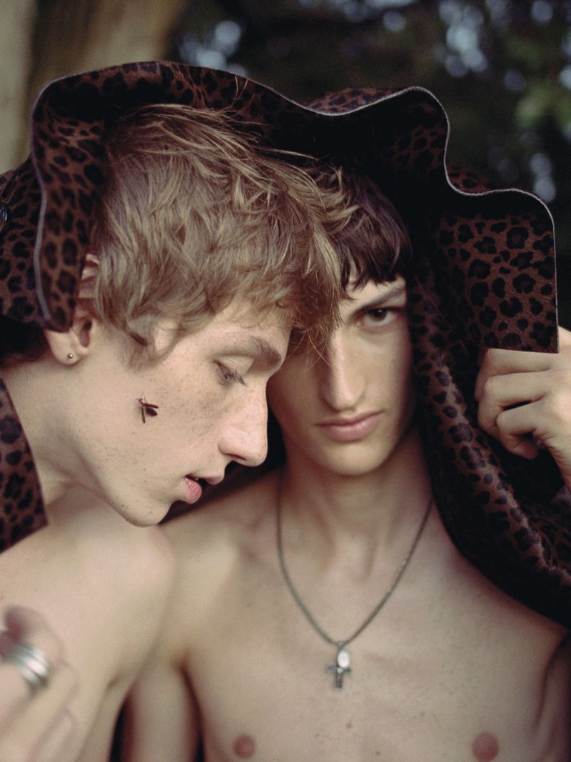Two young male models share a leopard print hat outdoors in a portrait for The Reminiscence Issue by AJ Kyser.