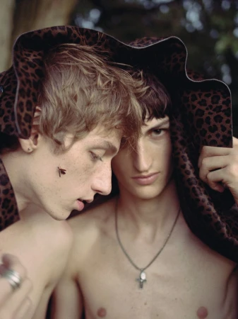 Two young male models share a leopard print hat outdoors in a portrait for The Reminiscence Issue by AJ Kyser.