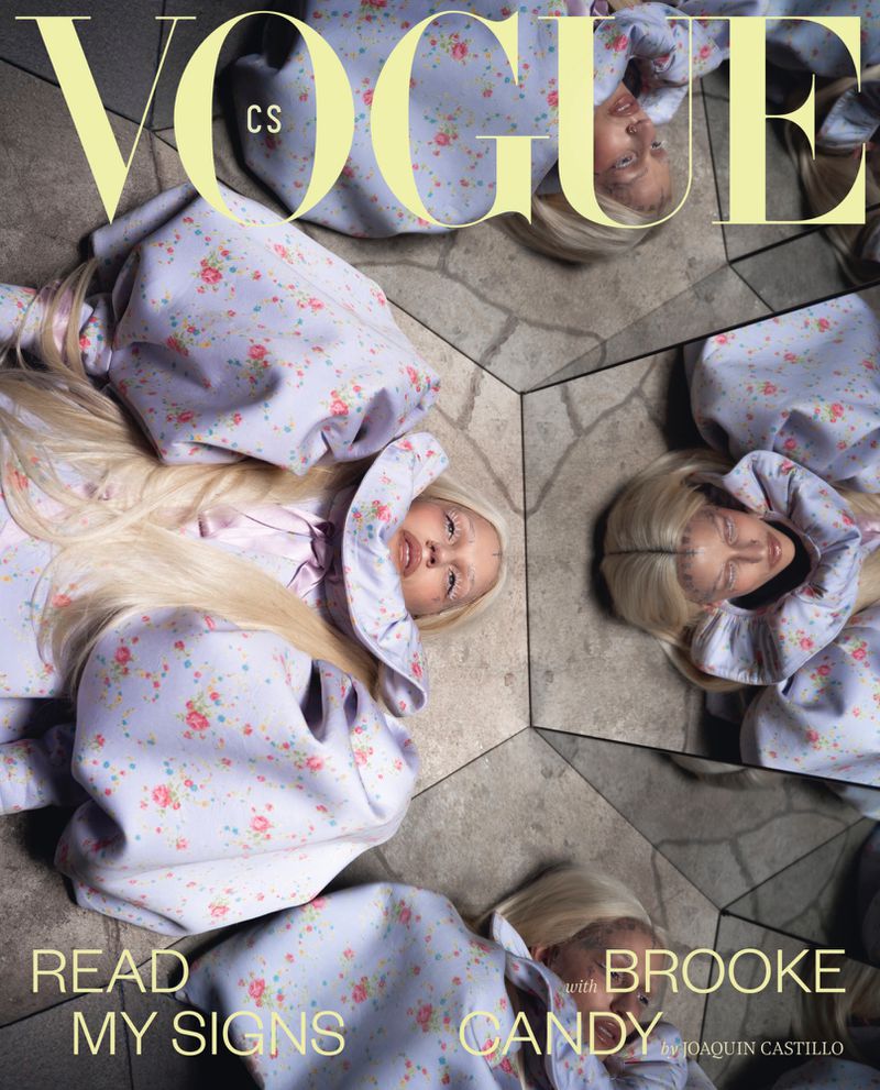 Editorial fashion magazine cover featuring a model in a floral dress lying among mirrored surfaces, reflecting multiple views.