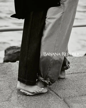 Close-up crop of two barefoot people standing together outdoors in rolled-up trousers for Banana Republic.