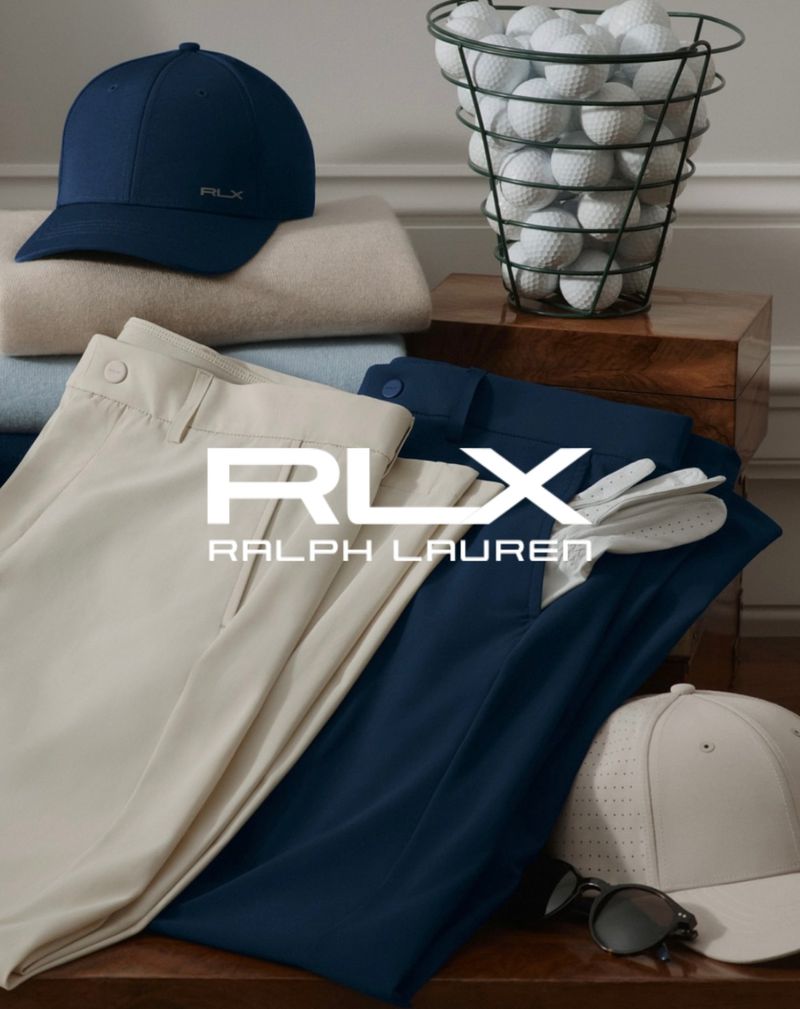 RLX Ralph Lauren golf apparel and accessories: caps, pants, glove, sunglasses, and golf balls in a wire basket on a wood surface.