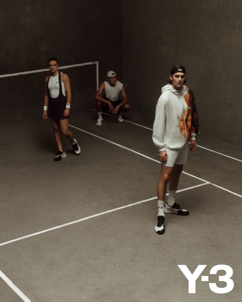Three men in sportswear pose indoors on a grey court with white lines, showcasing a Y-3 branded sweatshirt and athletic wear.