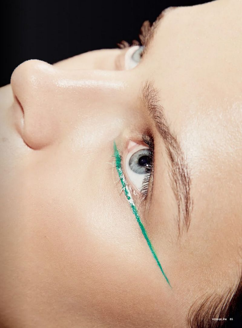 Extreme close up portrait of a woman wearing bright green eyeliner for a Vogue Philippines beauty editorial shoot.