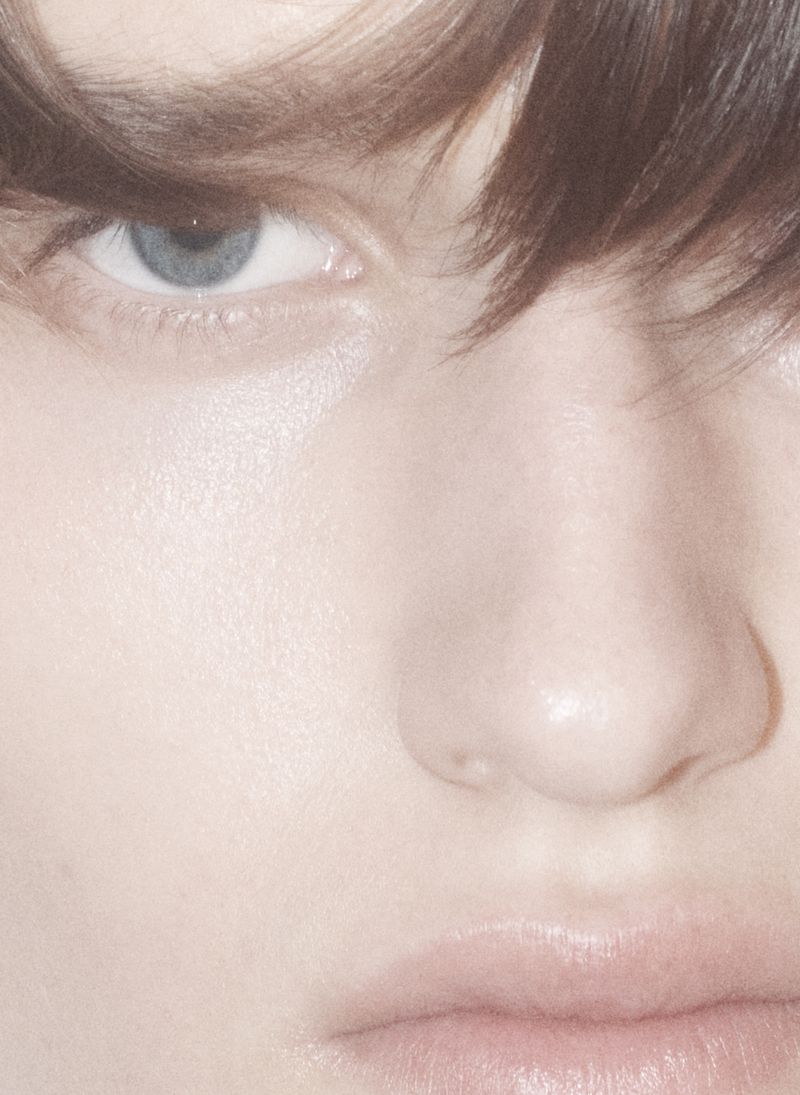 Close-up portrait of a model's face focusing on eye and nose with soft lighting for an editorial beauty story.