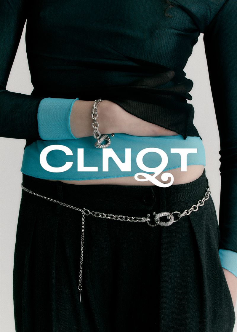 A person models a silver chain bracelet and a silver chain belt with a lock clasp detail against a light background.