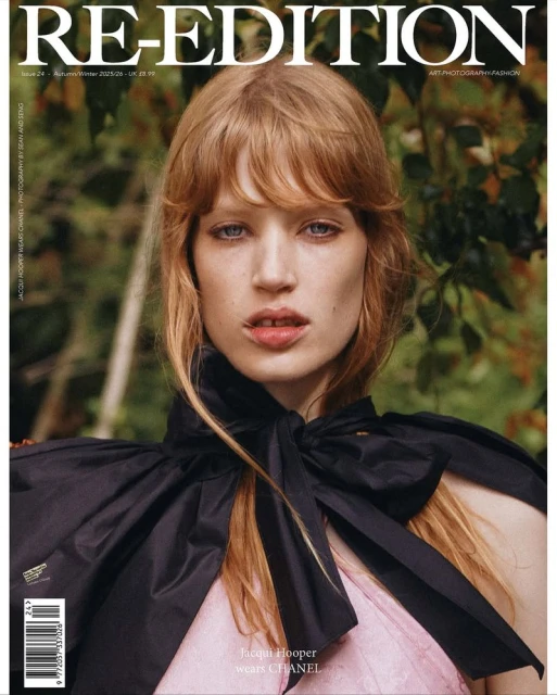 Fashion magazine cover featuring a woman with red hair wearing a black cape-like collar and pink dress, posing in an outdoor setting.