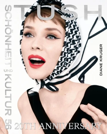 Close-up portrait of Diane Kruger wearing a black and white patterned headscarf and a black top against a plain white background.