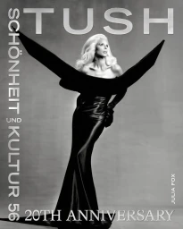 Julia Fox wearing a structured black gown with winged shoulders on Tush Magazine cover against a grey background.