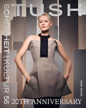 Model Maike Inga wearing a grey strapless structured dress with a black neckpiece against a geometric architectural background.