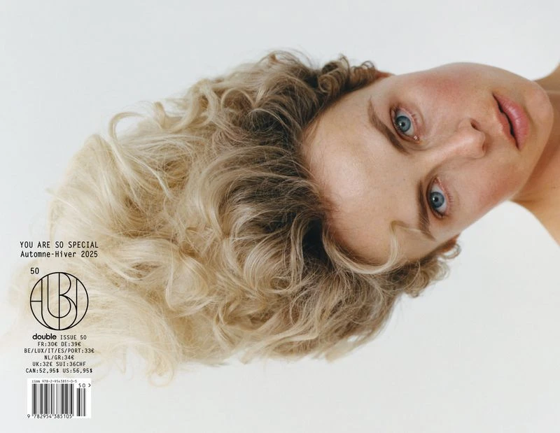 Blonde woman with blue eyes is featured on the cover of 'Double' magazine, against a plain white background, with visible magazine text.