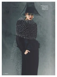 Model in black polka dot cape and sculptural sheer hat against a textured grey background for Vogue Philippines editorial.