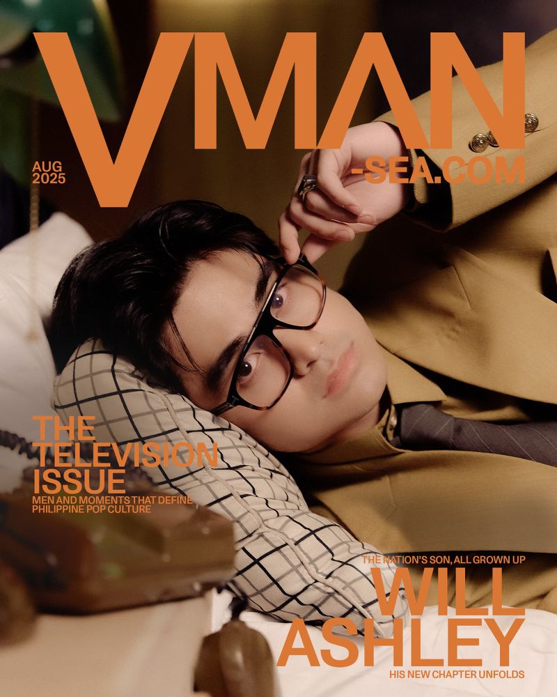 VMAN magazine cover featuring Will Ashley reclining on a pillow in a brown suit, wearing glasses, August 2025 edition. 