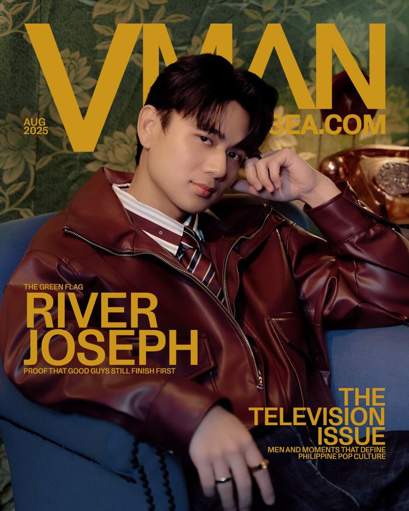 Magazine cover featuring a young Asian man in a leather jacket sitting in a blue chair with a floral wallpaper background and a telephone.